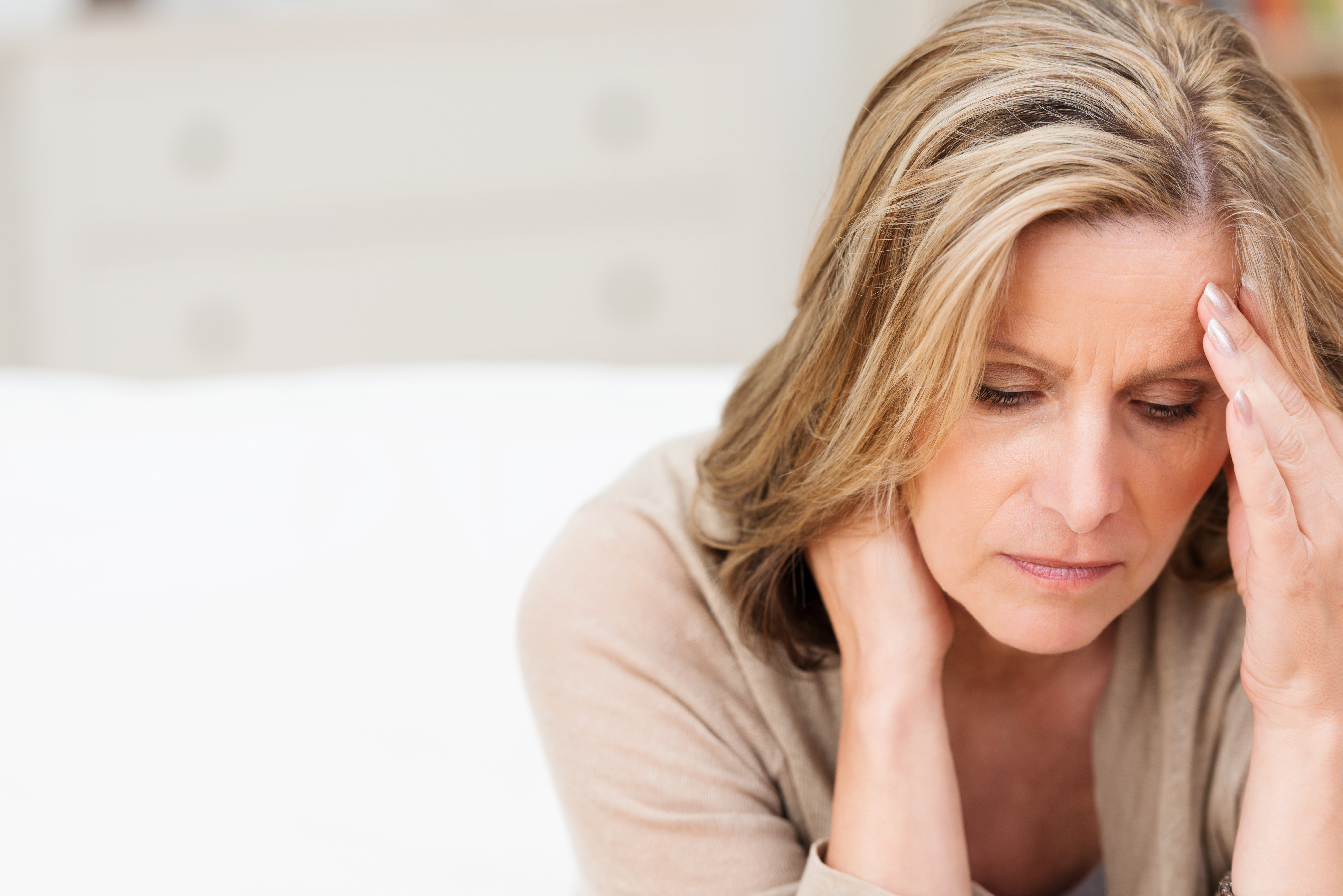 Stressed woman with head in hand