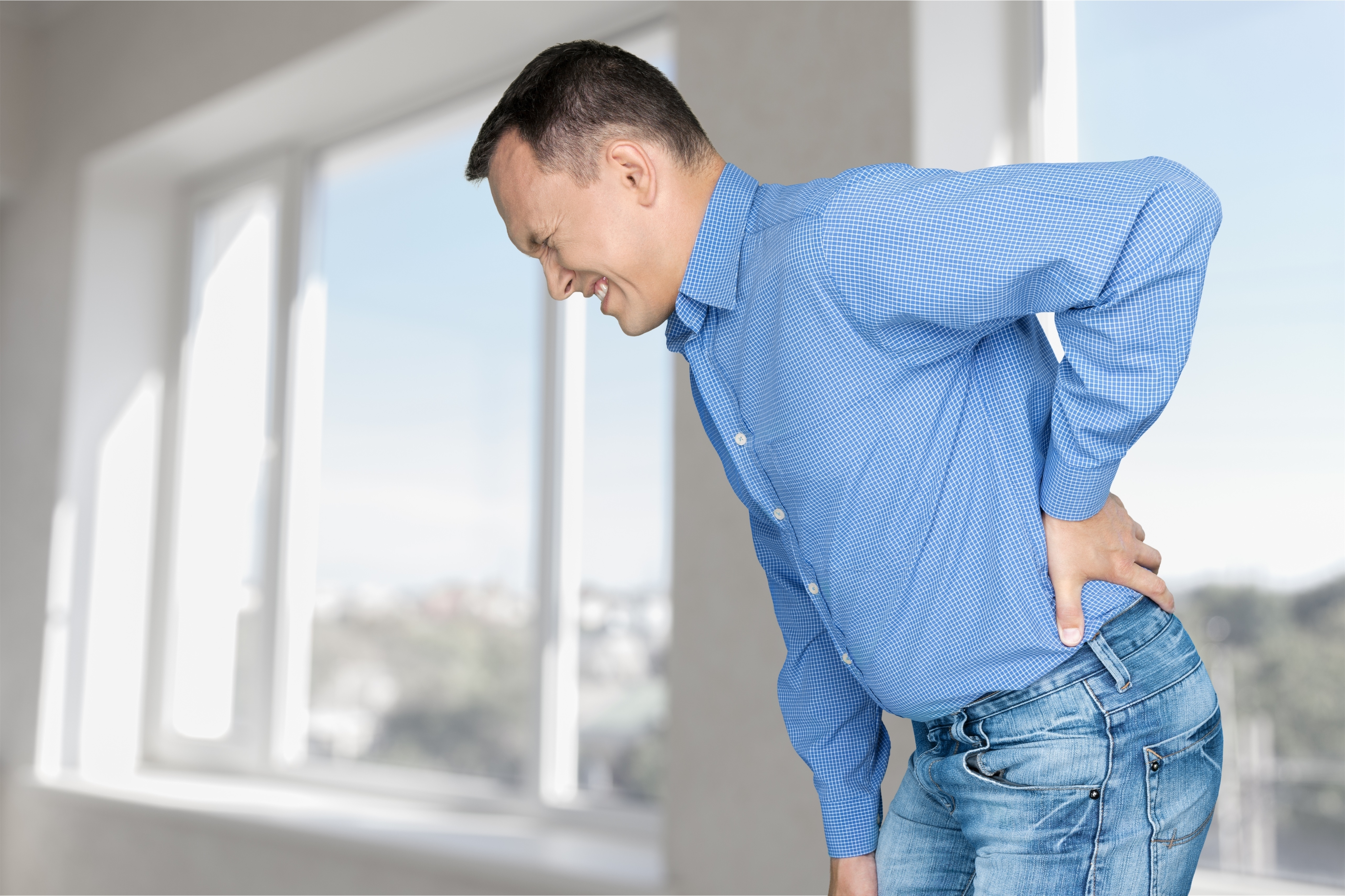 Man bent over with pain in lower back